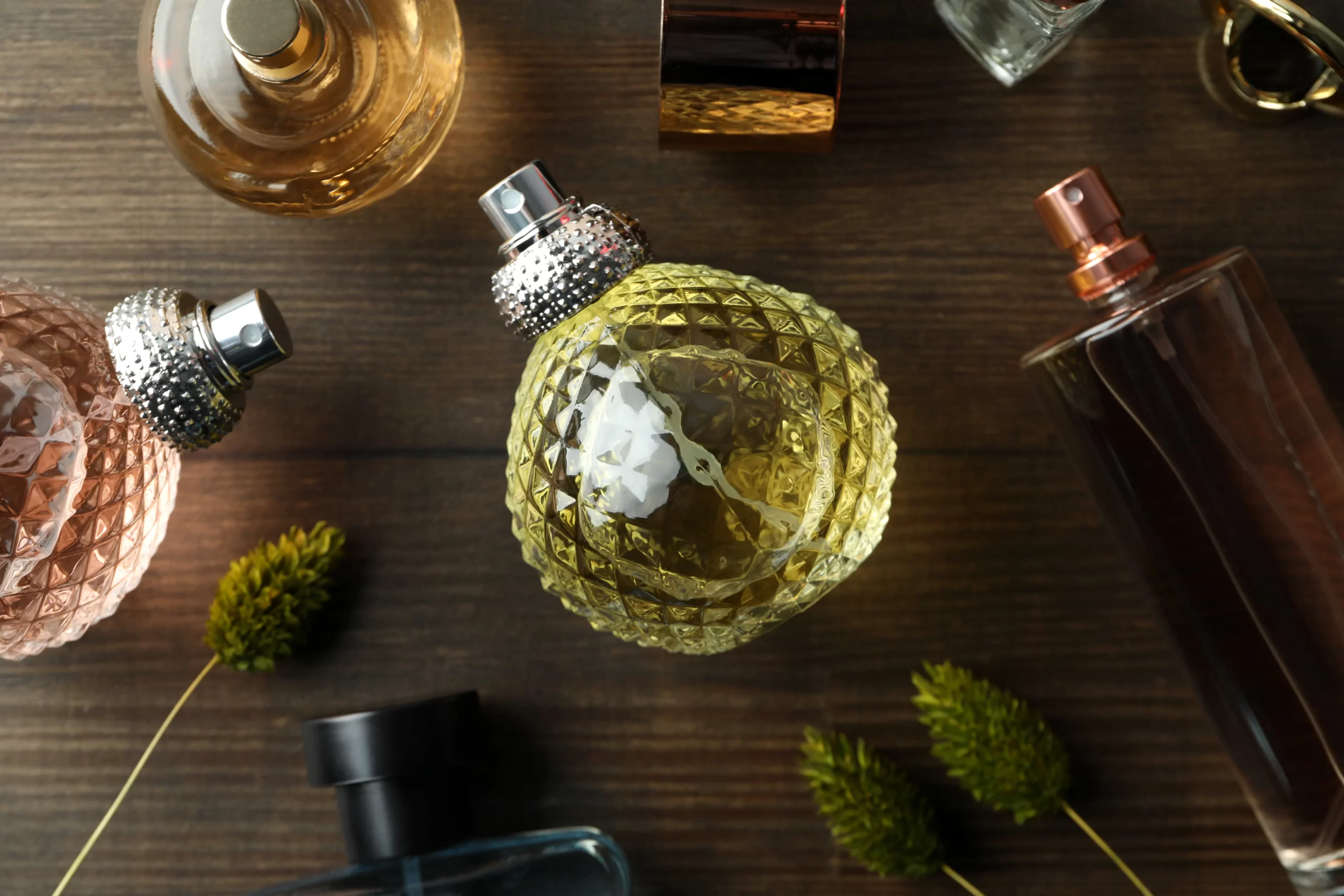 bottles-of-perfumes-on-wooden-background-top-view-2025-03-24-12-08-00-utc